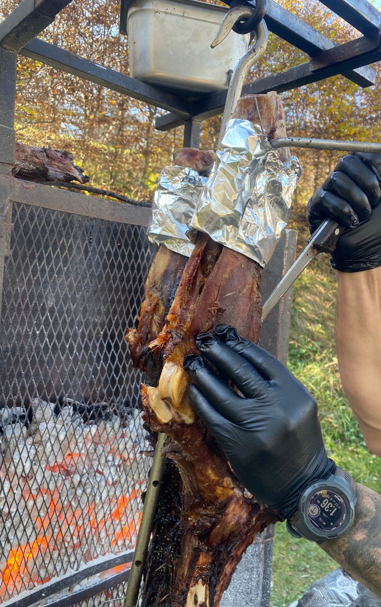 Découpe de viande cuite à la broche devant les braises